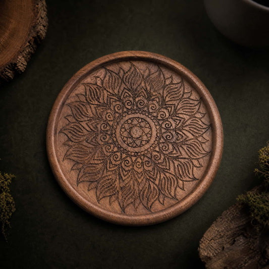 Hand-carved walnut coaster with floral mandala pattern, top view on dark background