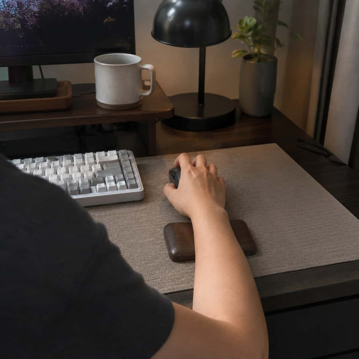 Walnut hand rest in hand, showing size and ergonomic fit for desk use