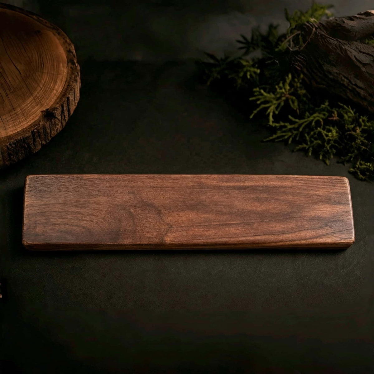 Handcrafted walnut wrist rest plain design, top view on dark background